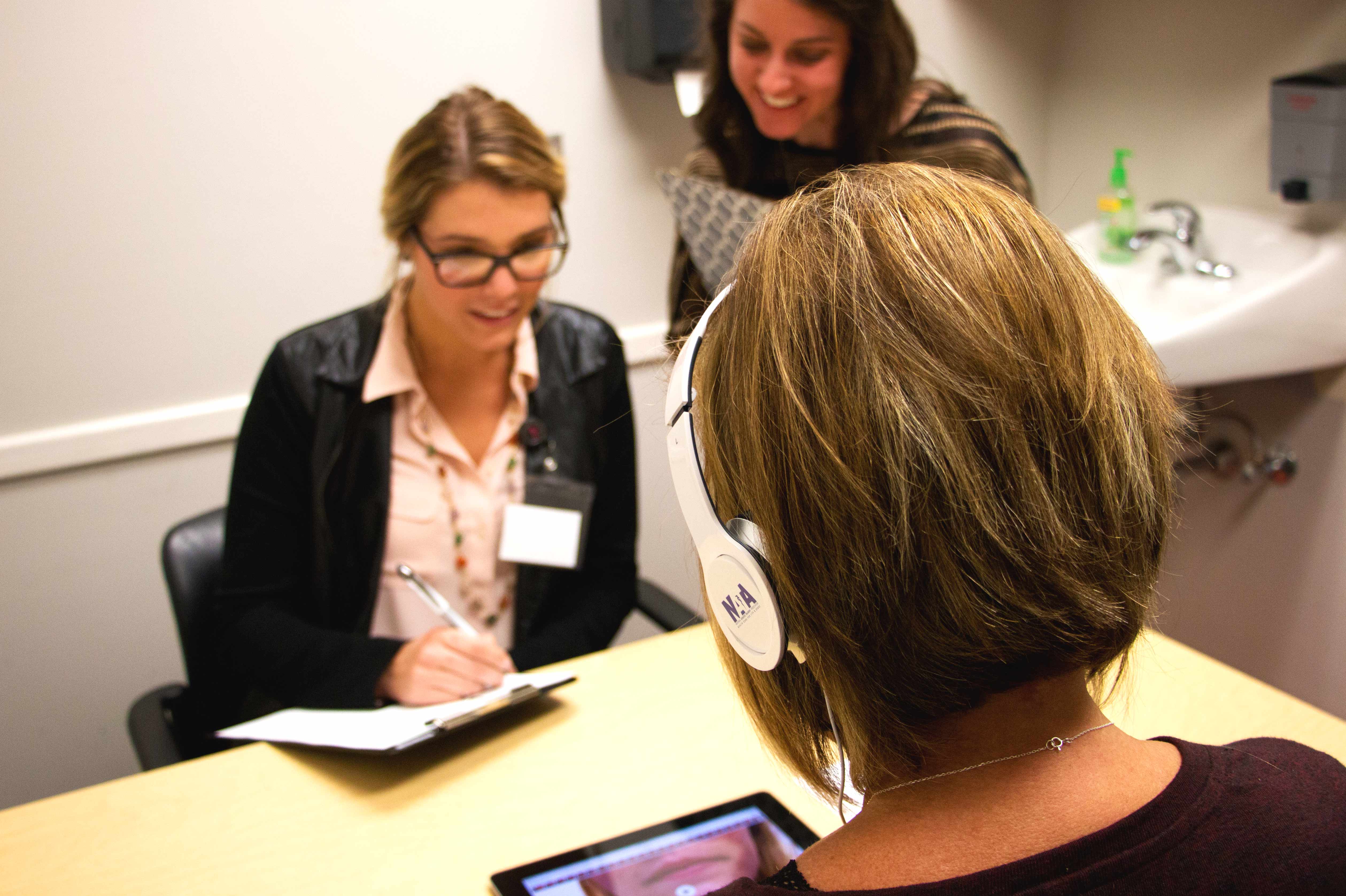 two therapists use an iPad to evaluate a client